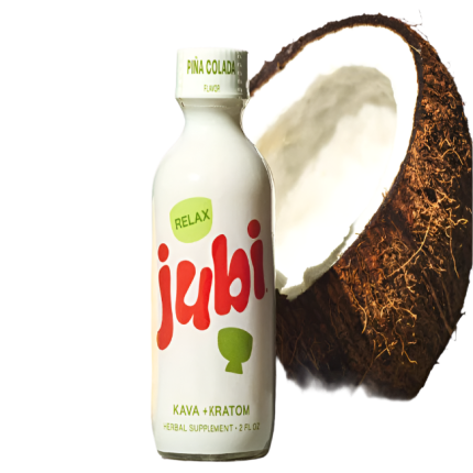 Bottle of jubi Kava + Kratom next to a coconut on a white background